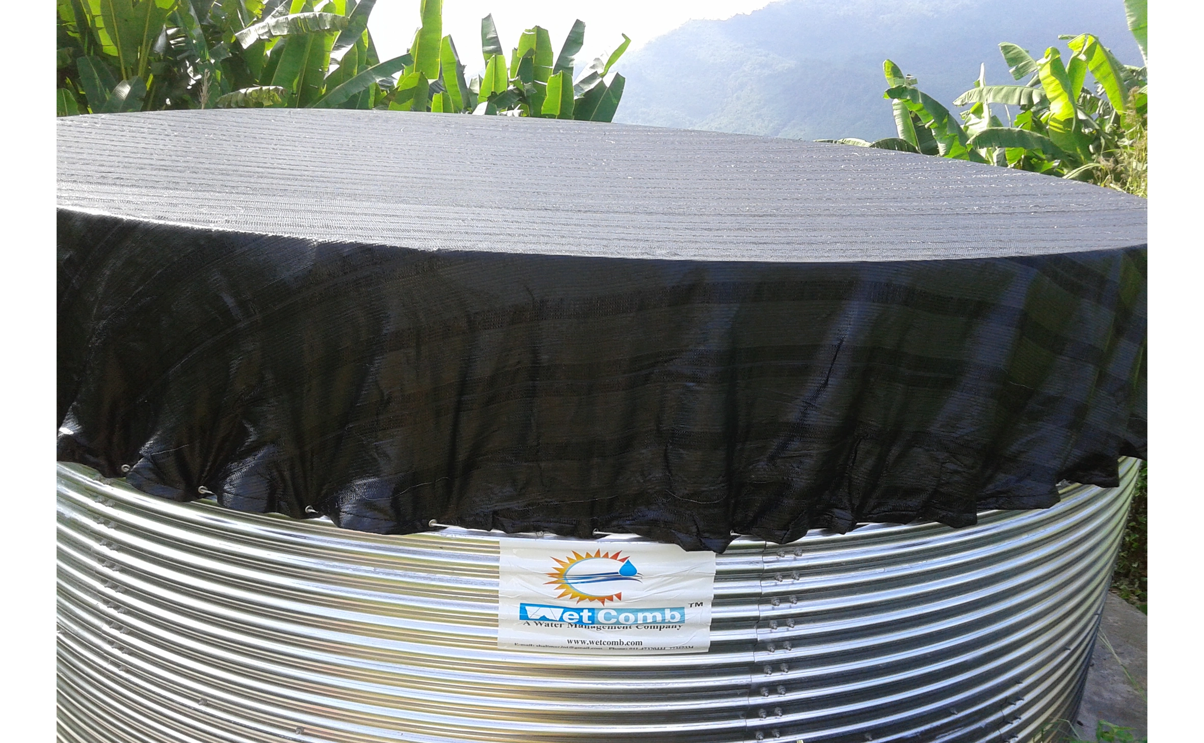 A large corrugated Rain Water Harvesting Tank covered with a black tarp